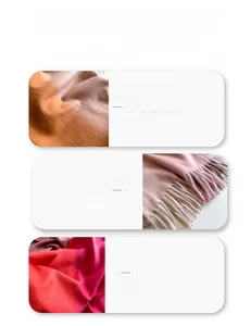 Detail eines Wollschals mit orangefarbenen Streifen und weichen rosa Fransen