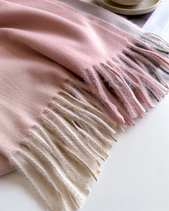 Nahaufnahme von Schal in Rosa und Creme mit weicher Textur und feinen Fransen am Saum
