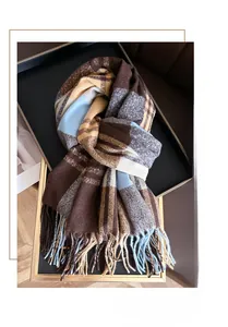 Detail view of rainbow plaid scarf with fringe tassels in deep brown and light blue colors
