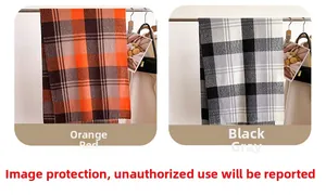 Detail of plaid scarves in orange and black-grey with elegant fringe tassels