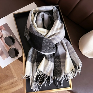 Detail view of rainbow plaid scarf with soft tassels on a luxury stylish background