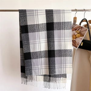 Detail of classic black grey plaid scarf texture with elegant soft fringe tassels