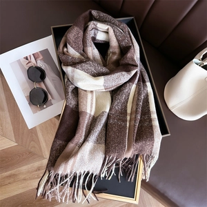 Close-up of soft cashmere-like brown plaid scarf with fringe details in elegant setting