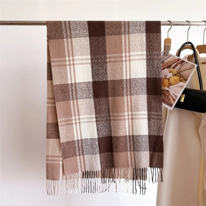 Detail of warm rainbow plaid scarf with fringe accents on a metal hanger display