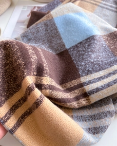 Close-up of soft rainbow plaid cashmere-like scarf texture with blue and camel tones