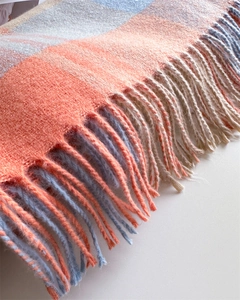 Close-up of rainbow plaid cashmere shawl showing thick fringe and soft knit texture