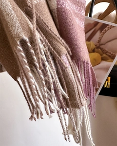 Detailed close-up of rainbow plaid cashmere scarves with soft fringe and warm fuzzy texture