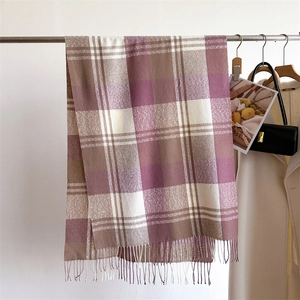 Close-up of rainbow plaid cashmere-like scarf with fringe details and soft texture