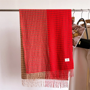 Détail d'une écharpe à carreaux rouge et marron avec franges et texture type cachemire