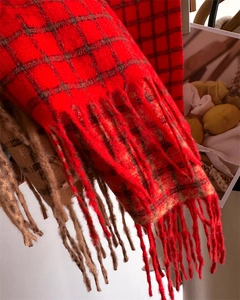 Détail d'une écharpe douce à carreaux rouges avec franges pour la chaleur hivernale