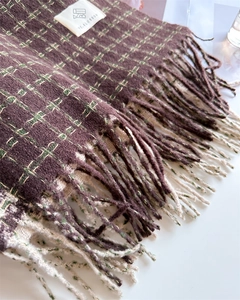 Gros plan d'une écharpe à carreaux effet cachemire avec de longues franges et texture
