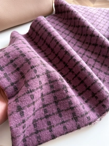 Gros plan sur un tissu doux au toucher cachemire avec motif à carreaux et franges
