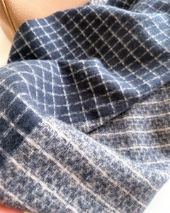 Gros plan sur l'écharpe à carreaux bleu et gris avec texture douce aspect cachemire