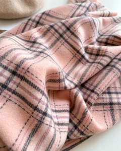 Gros plan détaillé de l'écharpe à carreaux rose en cachemire avec texture tissée douce