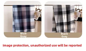 Dettaglio di una morbida sciarpa effetto cashmere con motivo a quadri e nappe blu e grigie