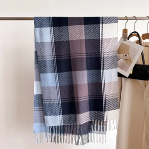 Dettaglio della sciarpa a quadri blu e marroni con frange spesse e morbida trama in cashmere