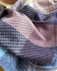 Macro di una sciarpa a quadri stile nordico con morbida trama a saia viola e grigio