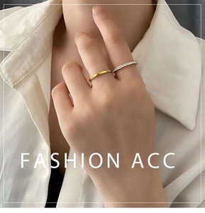 Close-up of minimalist gold plated band and sparkling zircon ring set on finger
