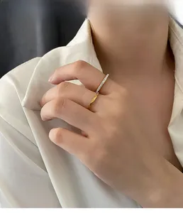 Detail of stacked titanium steel rings featuring a gold rhombus band and zircon silver ring
