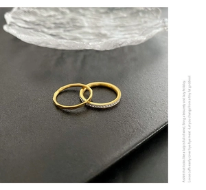 Macro view of gold-plated stacked rings featuring hammered texture and pavé set crystals