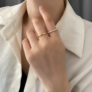 Minimalist titanium steel ring set with zircon accents shown on finger in two-tone finish
