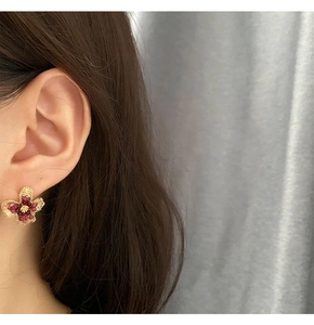 Macro detail of luxury pink flower earring showing gradient petals and golden texture