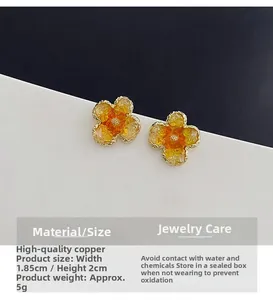 Detail view of orange resin flower earring with copper base measuring 1.85cm by 2cm