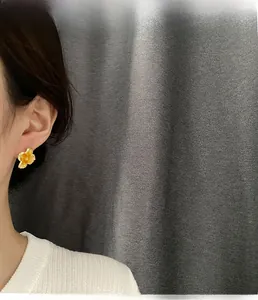 Detailed model view of sweet orange floral stud earrings with translucent resin petals