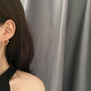 Elegant burgundy flower stud earrings with gold edges worn for a daily commute style