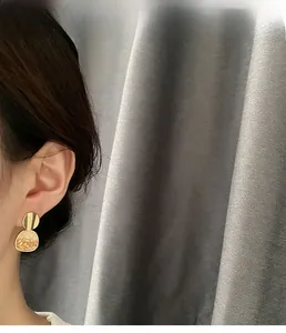 Dettaglio di una modella che indossa orecchini retrò in resina ambra e finitura dorata