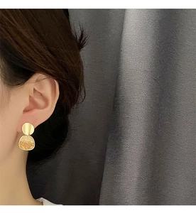 Primo piano di orecchini S925 geometrici con pietre d'ambra indossati da una modella