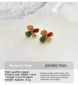 Macro shot of colorful floral stud earrings in green and red with size 1.4x1.3cm detail