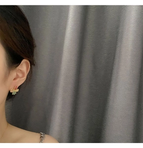 Detailed close-up of a vintage floral earring with pink and yellow resin petals on model