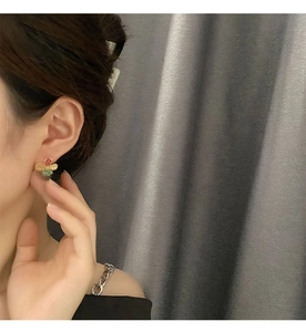 Close-up of a colorful matte flower stud earring worn on a model for a vintage look