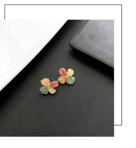 Macro detail of vintage floral stud earrings featuring colorful stone petals and gold base