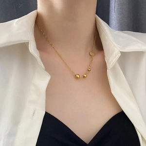 Minimalist titanium steel gold necklace with metal beads and disc pendant on model neck