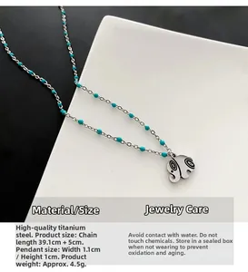 Detail view of titanium steel elephant necklace showing 39.1cm length and turquoise beads