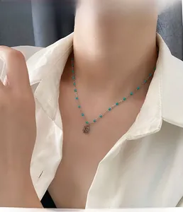 Détail du collier pendentif Fu avec perles bleues et chaîne en acier inoxydable