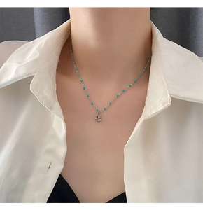 Détail du collier en argent avec perles bleues et pendentif Fu porté par un mannequin