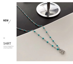Vue détaillée du collier de perles turquoise avec pendentif symbole Fú en argent