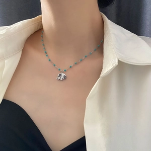 Minimalist elephant pendant necklace in silver steel with blue beads on female model