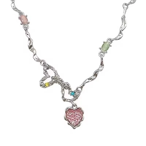 Detail of silver heart pendant with colorful crystals and wavy chain design