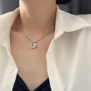 Minimalist silver elephant pendant necklace with turquoise beads on a steel chain