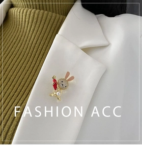 Detail of cute rabbit brooch with crystals and pearl on a white blazer lapel