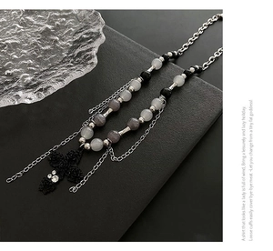 Gros plan détaillé du pendentif croix rétro avec perles marbrées et textures dentelle