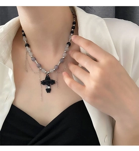 Détail du collier croix gothique avec roses et chaînes perlées sur un mannequin