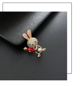 Close-up of cute rabbit brooch with white pavé crystals and red carrot accent