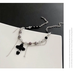 Détail du collier à deux rangs avec croix gothique et perles sur chaîne argent
