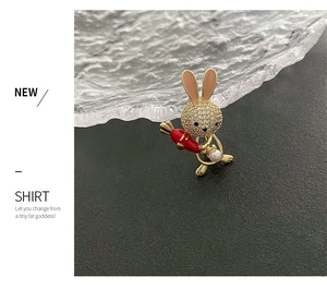 Detail of cute bunny brooch with rhinestones, pink ears, carrot, and pearl decoration