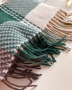 Dettaglio della trama a maglia scozzese con frange soffici in verde e beige neutro